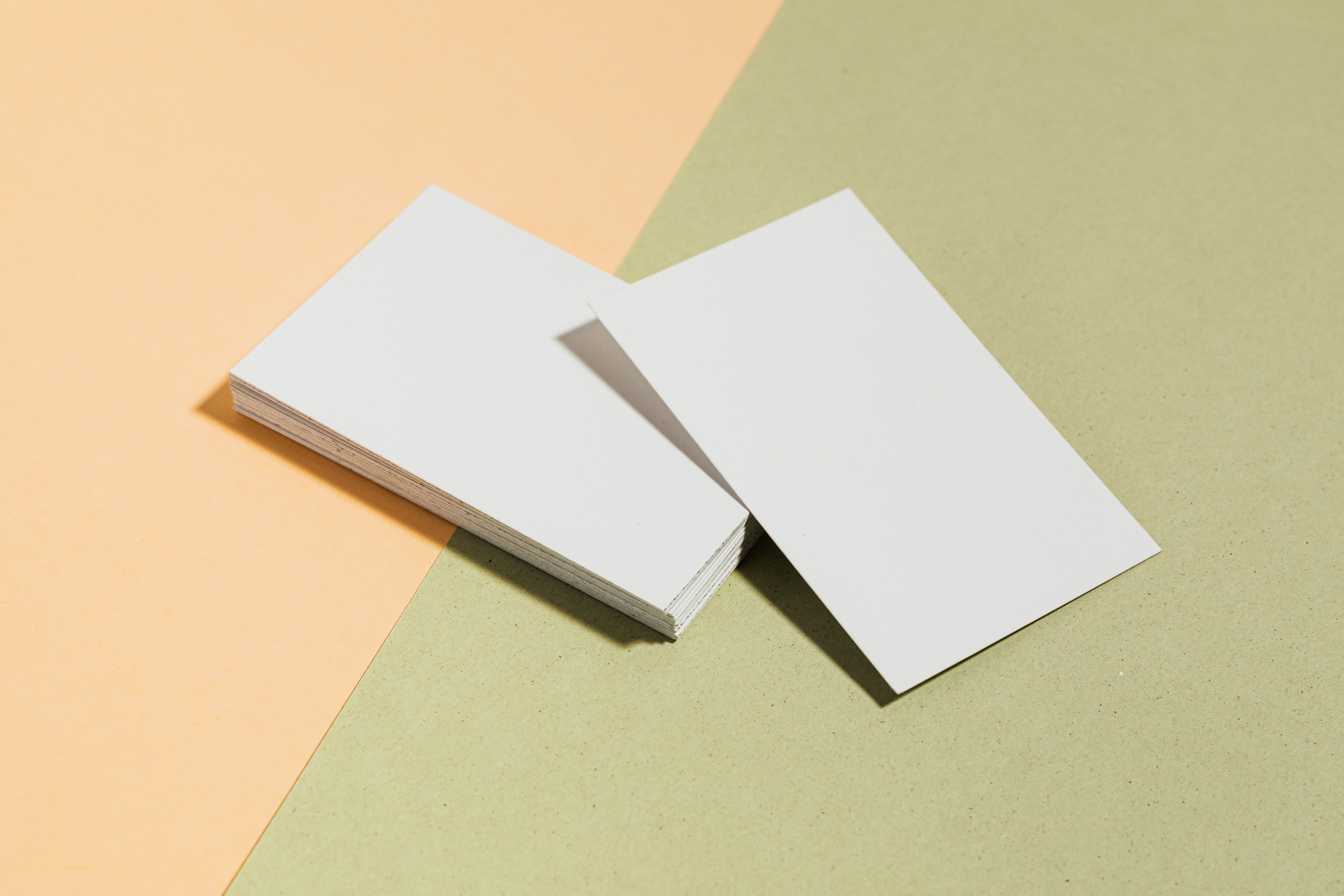 A stack of blank business cards on a pastel tabletop