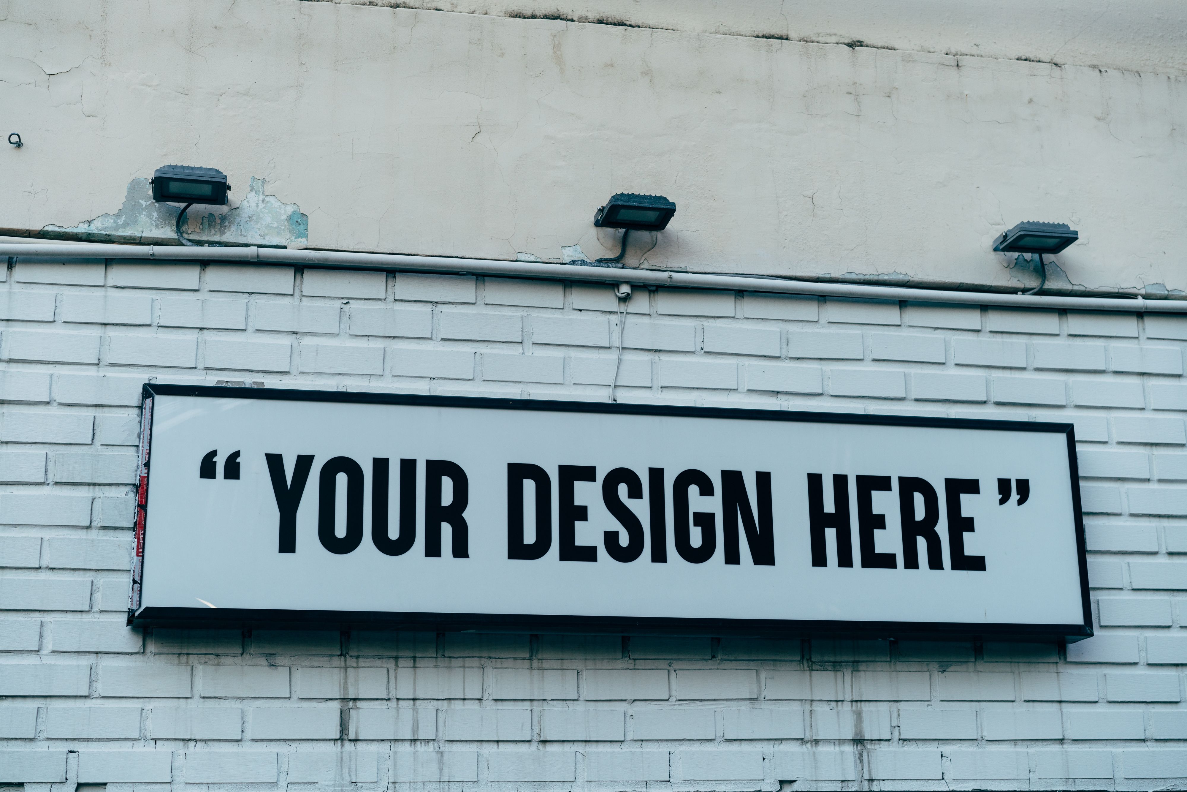 A large outdoor sign mounted on a white brick wall