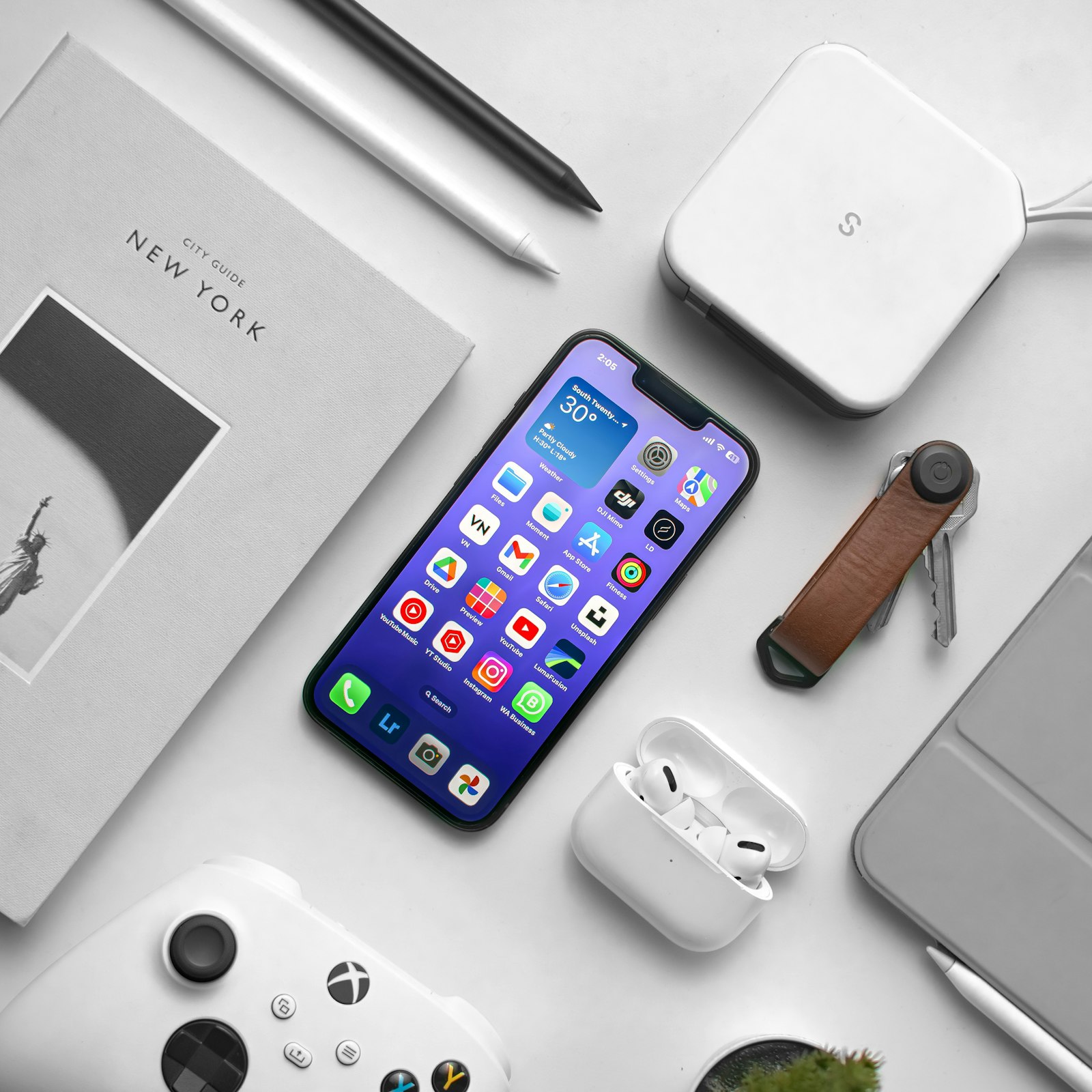 A smartphone laid out with everyday tech accessories on a desk